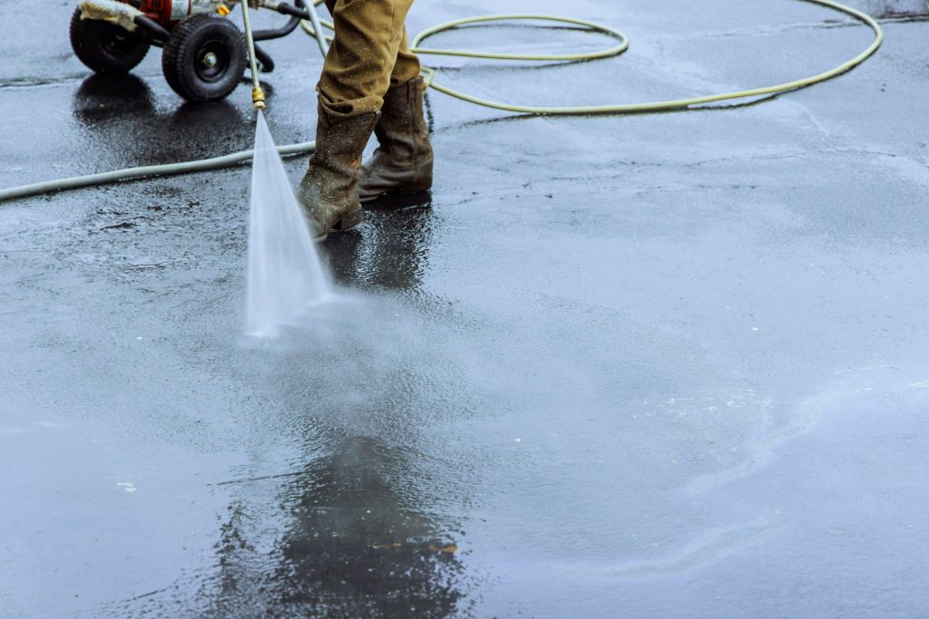 Using pressurized water to clean a street, wet washing roadway