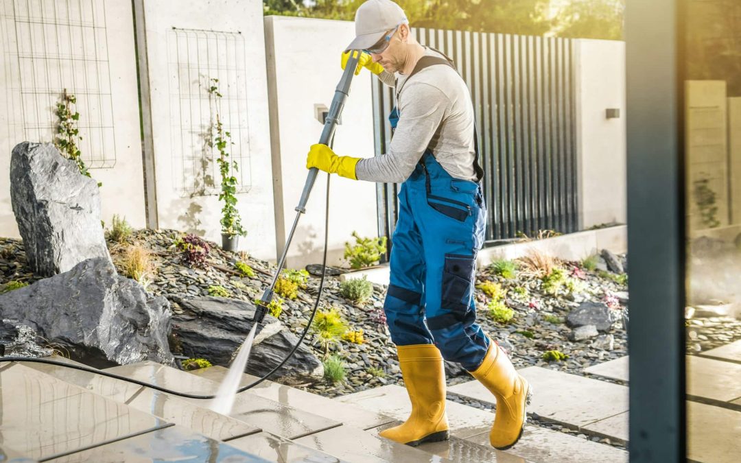 A man doing pressure washing in lawn